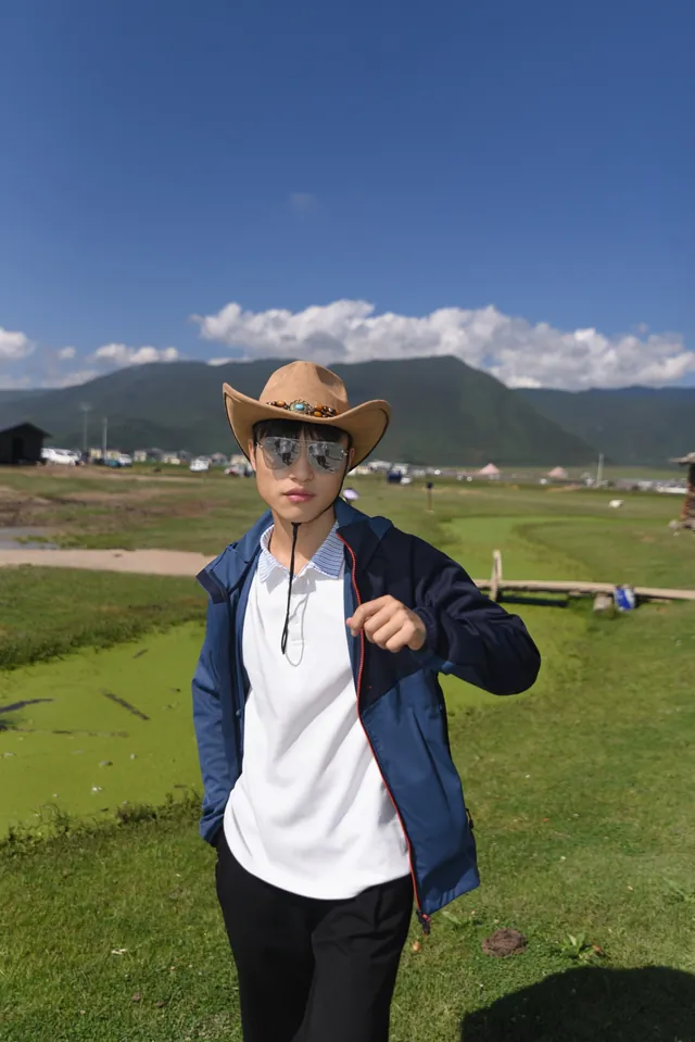草原上的林扬洋，戴着牛仔帽